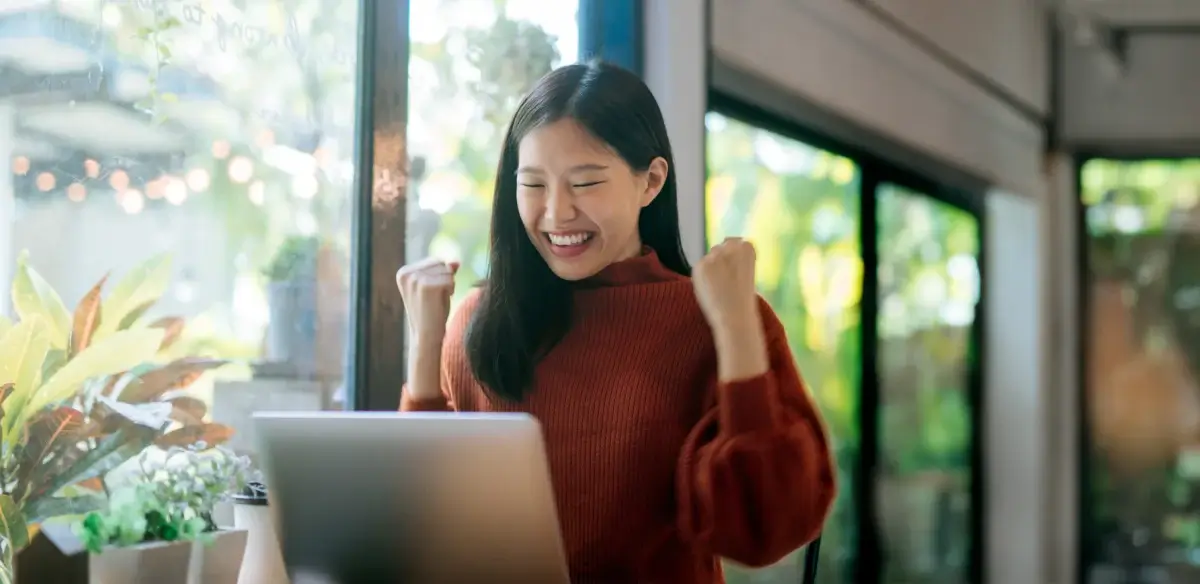 Girl attending to an online class wearing a red sweater